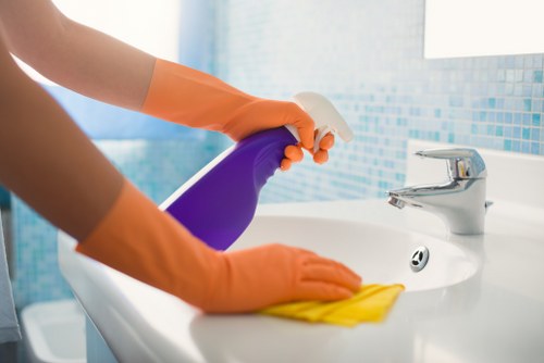 Professional cleaner tidying a kitchen in an E9 property